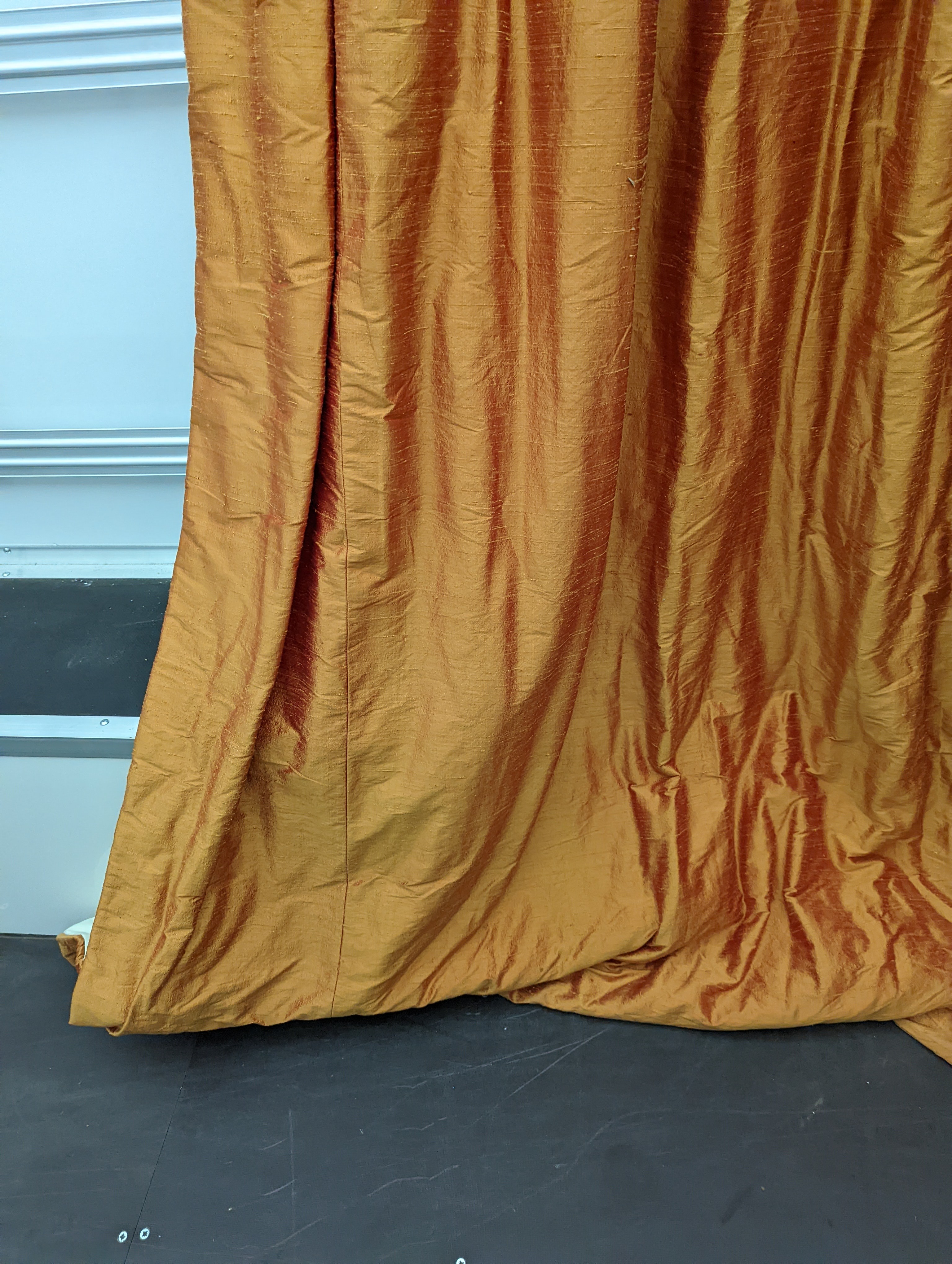 A pair of orange lined curtains. Approximate measurements: Width of top 180cm, Width of bottom 320cm Length 250cm